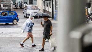 Archivo - Dos personas caminan bajo la lluvia, en Madrid (España).
