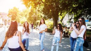 Gorgeous young girls taking photos on the treet on a sunny day.