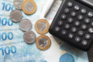 Finance concept one hundred reais bills and coins with calculato