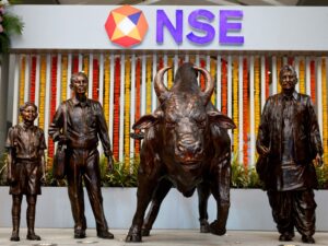 FILE PHOTO: Statues of people and a bull are seen next to the logo of the National Stock Exchange (NSE) in Mumbai