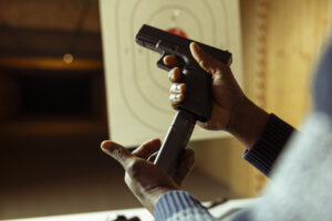 Close up of person reloading ammunition bullets into pistol