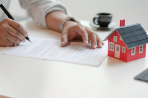 Close-up view of customer signing contract about home loan agreement