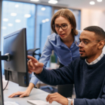 Digital Collaboration: Blonde Businesswoman and African American Partner Reviewing Documents Online